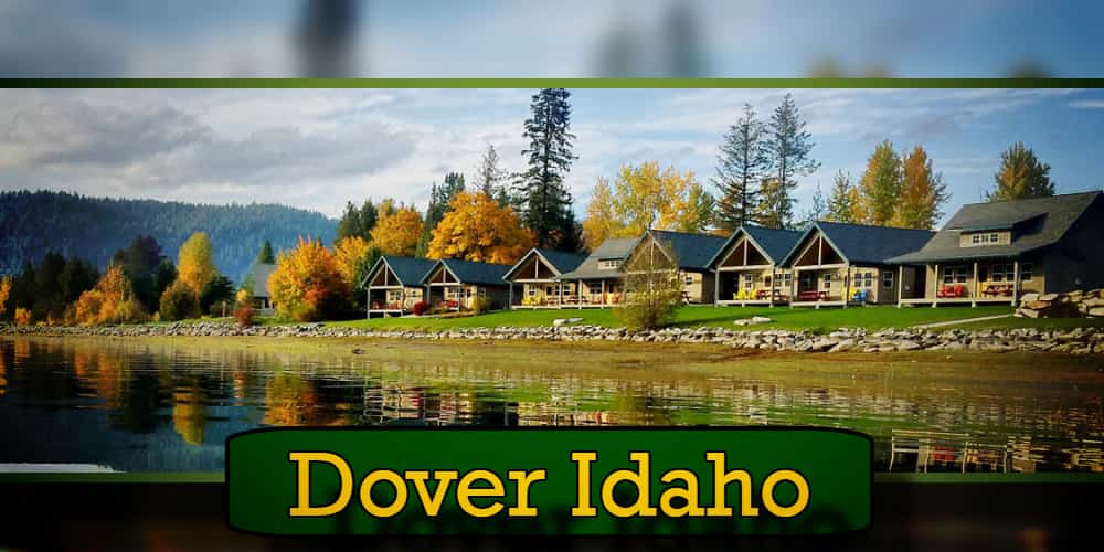 Scenic view of lakeside cabins surrounded by autumn trees reflecting in the water in Dover, Idaho, with a tow truck subtly parked nearby.
