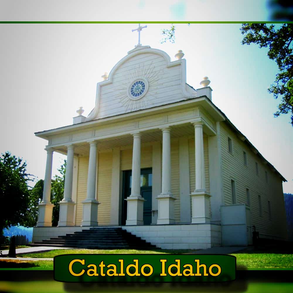 A white, historic church with large columns and a cross on top in Cataldo, Idaho, surrounded by green grass and trees. A tow truck passing by adds to the modern-day charm. Text at the bottom reads, 
