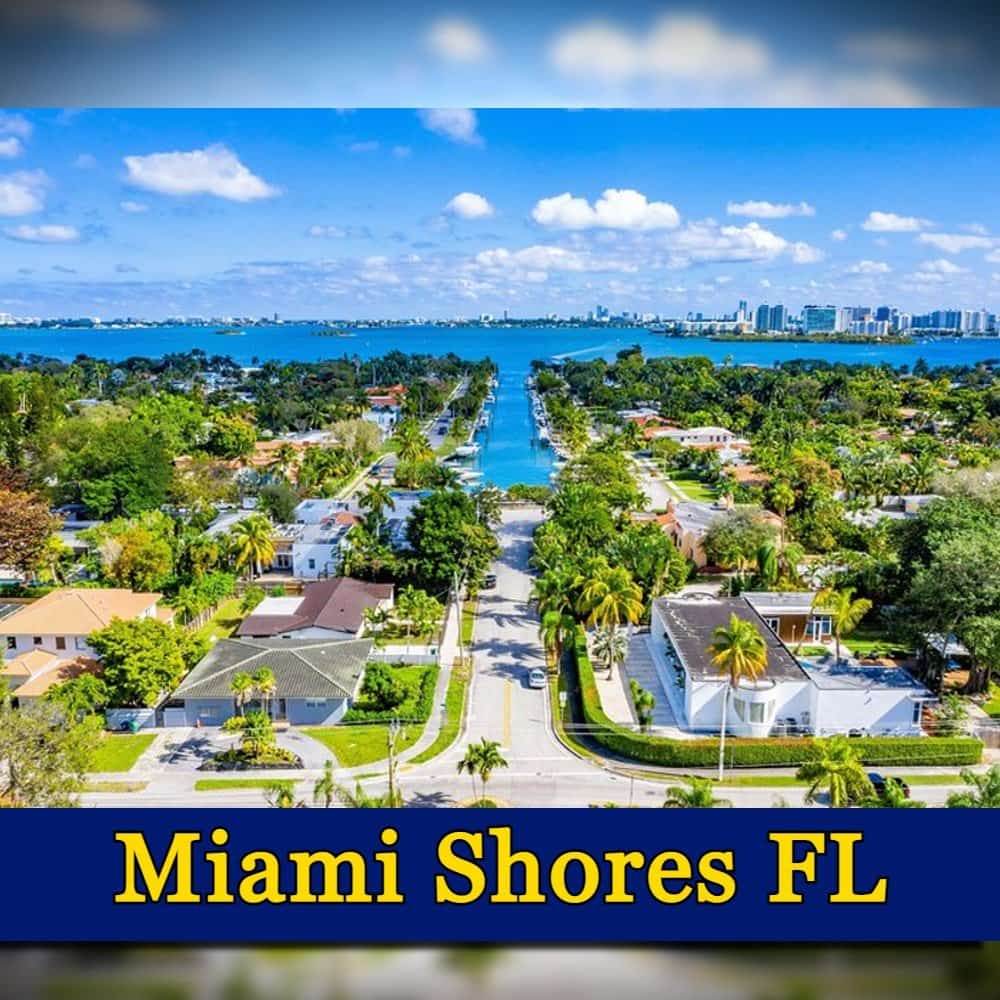 Aerial view of a residential neighborhood in Miami Shores, Florida, featuring houses with green lawns, palm trees, and a waterway in the background. A tow truck is visible on one of the streets. Text at the bottom reads 