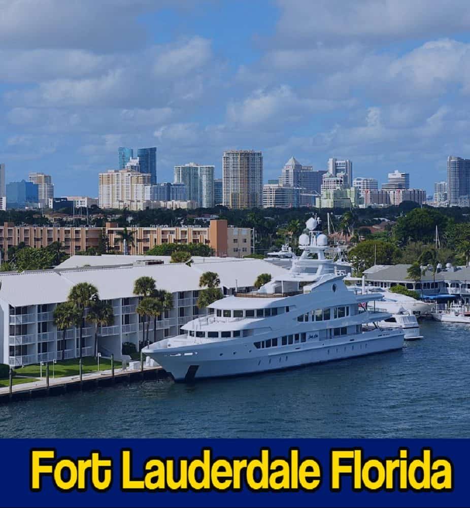 Large white yacht docked along the waterfront with Fort Lauderdale city skyline in the background. A tow service boat is visible nearby, ready for any maritime assistance. Text overlay reads 
