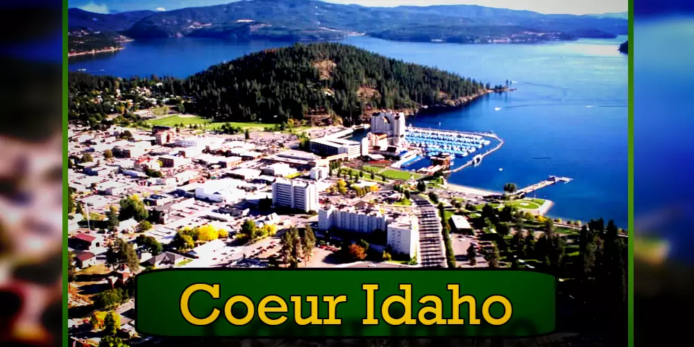 Aerial view of Coeur d'Alene, Idaho, featuring the city's buildings, marina, and surrounding forested hills by the lake. A tow service operates nearby, ensuring smooth travels for visitors exploring this scenic gem.