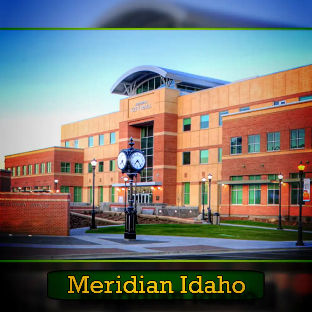 A multi-story brick building labeled Meridian City Hall, with a clock and streetlights in front, is shown at dusk. A sign reading 