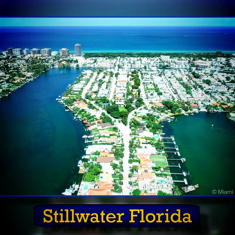 Aerial view of Stillwater, Florida, showing a residential area surrounded by water on three sides, with the ocean in the background. A tow truck is visible near the shoreline. Text at the bottom reads 
